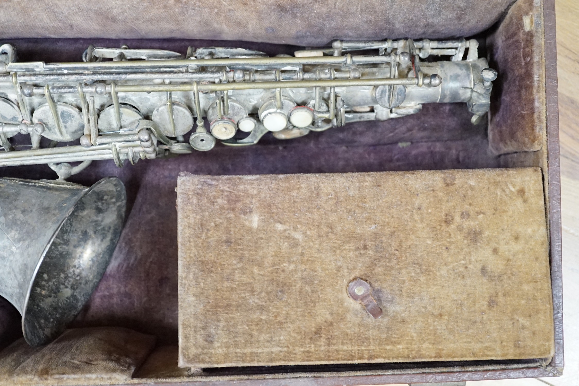 A cased saxophone marked ‘Lark, Shanghai, China M4021’